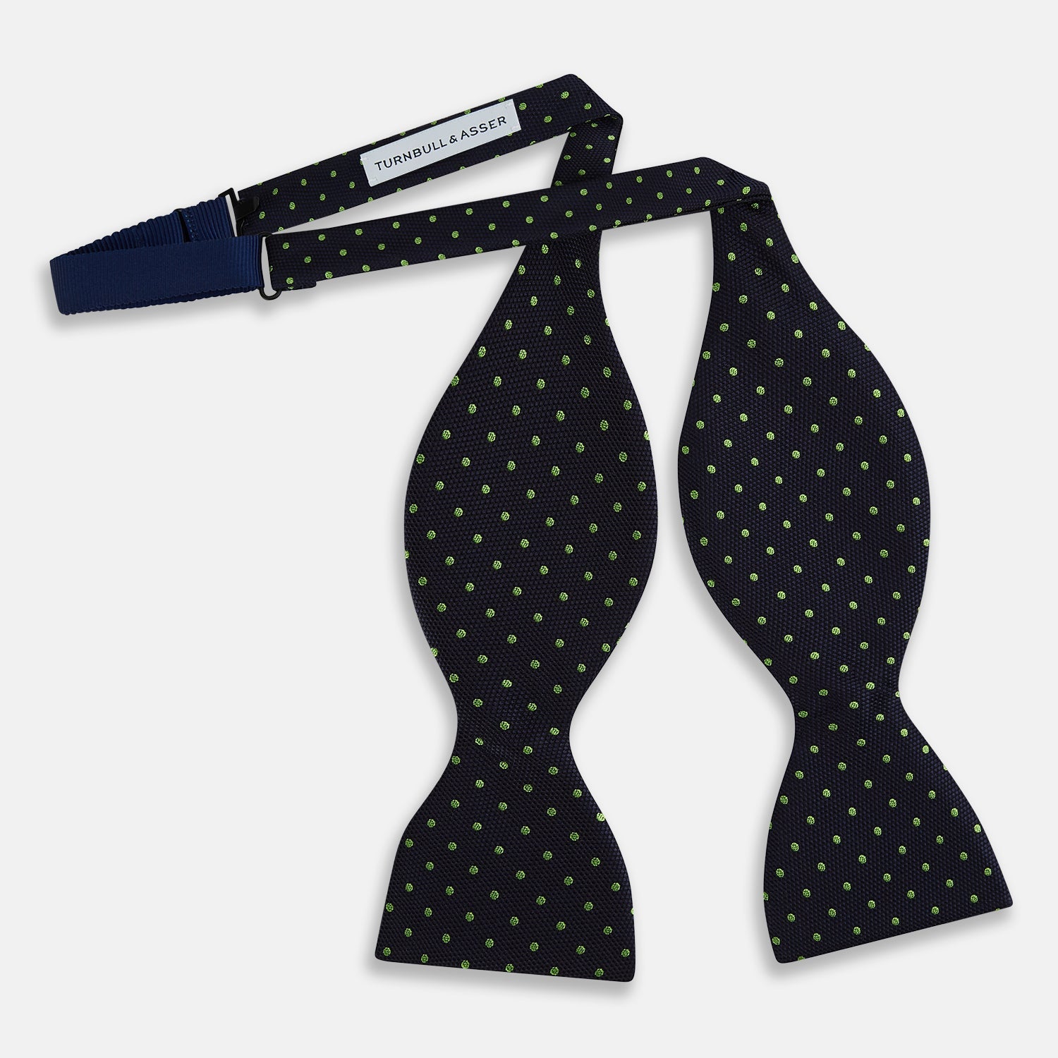 View 3 of product The Turnbull & Asser Lime Green and Navy Micro Dot Silk Bow Tie features small lime green dots on navy silk, displayed against a plain white background.