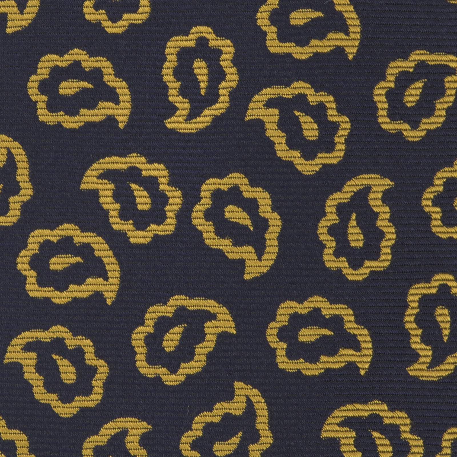 View 4 of product The Navy and Gold Petal Paisley Silk Tie by Turnbull & Asser features a repeating yellow abstract pattern, neatly rolled on a white background.
