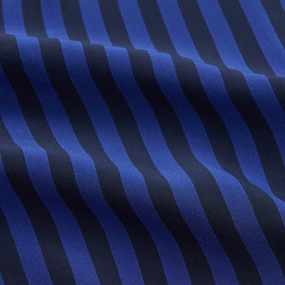 The Turnbull & Asser Blue and Navy Candy Stripe Silk Hyde Pyjamas Set features a long-sleeve button-up top with a chest pocket and elastic-waist pants, shown on a plain white background.