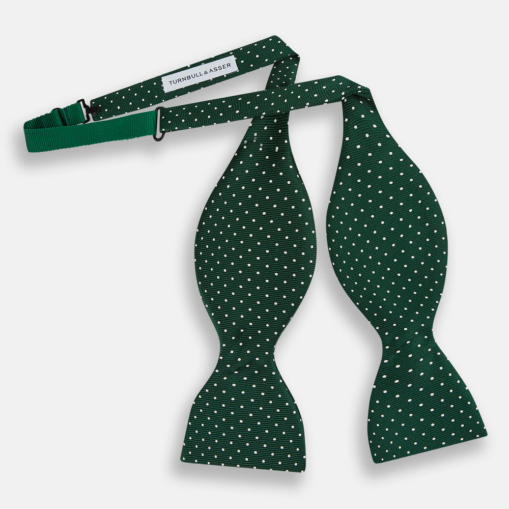 The Turnbull & Asser Racing Green and White Spot Silk Bow Tie features small white polka dots on luxurious silk, shown against a plain white background.