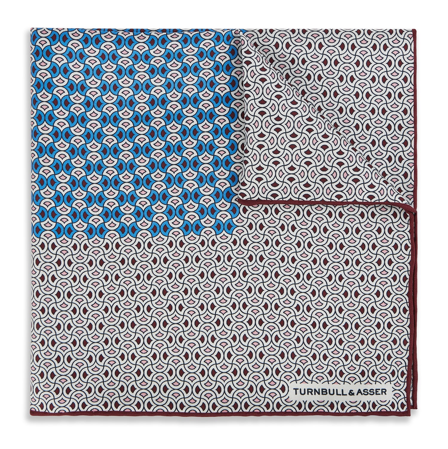 View 1 of product A geometric brown and blue silk pocket square from Turnbull & Asser UK, predominantly white with maroon and blue accents that suggest subtle burgundy tones, featuring a bold blue section in the top left corner and elegantly finished with the TURNBULL & ASSER branding in one corner.