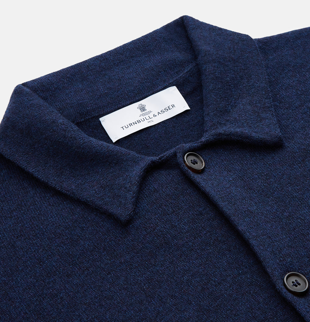 The Turnbull & Asser Navy Cashmere Knitted Traditional Pyjama Set features a long-sleeve camp collar shirt with front pockets and matching drawstring pants, offering an elevated twist on classic loungewear.