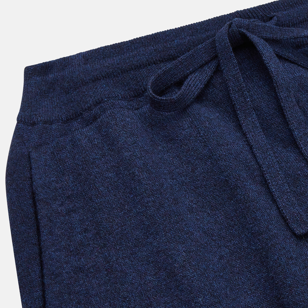 The Navy Cashmere Knitted Lounge Pyjama Trousers by Turnbull & Asser feature a contemporary fit, elastic waistband with drawstring, side pockets, and fitted cuffs, shown laid flat on a white background.