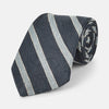 View 1 of product The Turnbull & Asser Blue & Silver Stripe Silk Tie, featuring wide diagonal stripes, is rolled up and displayed against a plain white background.