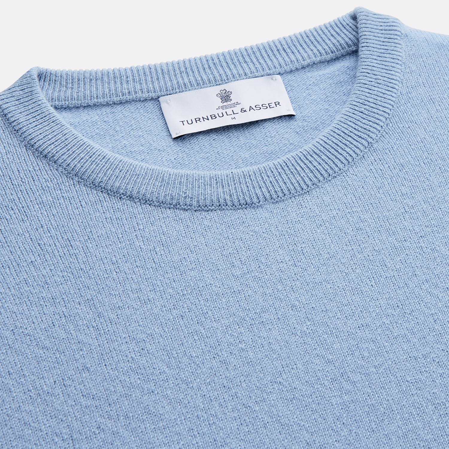 View 2 of product The Pale Blue Cashmere Glenn Jumper by Turnbull & Asser is laid flat against a white background. This men's crew neck essential features ribbed cuffs, hem, and neckline for timeless style.