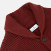 View 2 of product The Turnbull & Asser Burgundy Cashmere Ribbed Shawl Neck Ainsley Cardigan, featuring a button closure and two front pockets, is displayed flat on a white background.
