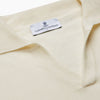 View 2 of product The Turnbull & Asser Ecru Merino Wool Roland Polo Shirt, made in Scotland, features soft merino wool, short sleeves, a relaxed open collar, and an inner neckline label. Shown here on a plain white background.