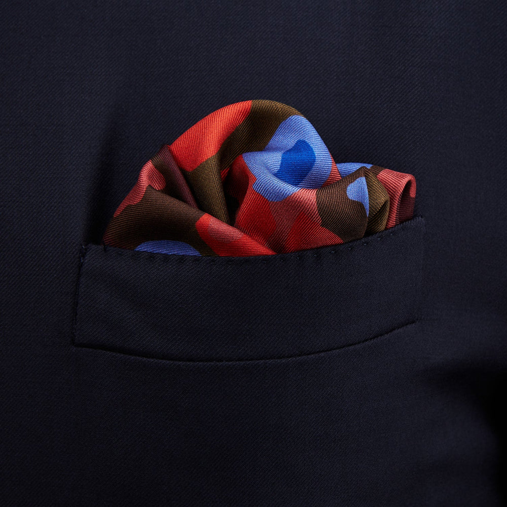 The Turnbull & Asser Green, Burgundy, and Pink Abstract Olives Silk Pocket Square features an abstract olive pattern with bold colors, a border, and corner text. Made in England.