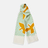 View 1 of product The Gold and Green Abstract Bird Silk Lawton Scarf by Turnbull & Asser features a white base with green checks, bold yellow Cubism-inspired bird motifs, and fringed edges, elegantly draped against a white background.