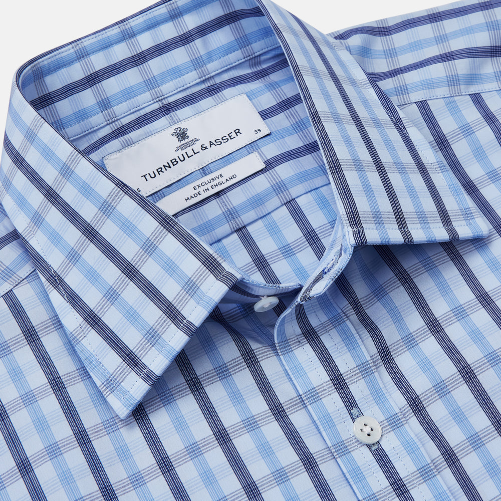 The Turnbull & Asser Light Blue and Navy Check Cotton Regular Fit Mayfair Shirt features a T&A collar and button-up long sleeves, displayed laid flat on a white background.