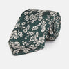 View 1 of product The Turnbull & Asser Dark Green Floral Garden Silk Tie features an elegant white floral pattern on dark green silk, shown rolled against a plain white background.