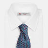 View 4 of product A rolled-up Pale Blue and Purple Art Deco Silk Tie by Turnbull & Asser, handmade in England, is displayed on a plain white background.