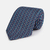 View 1 of product A rolled-up Pale Blue and Purple Art Deco Silk Tie by Turnbull & Asser, handmade in England, is displayed on a plain white background.
