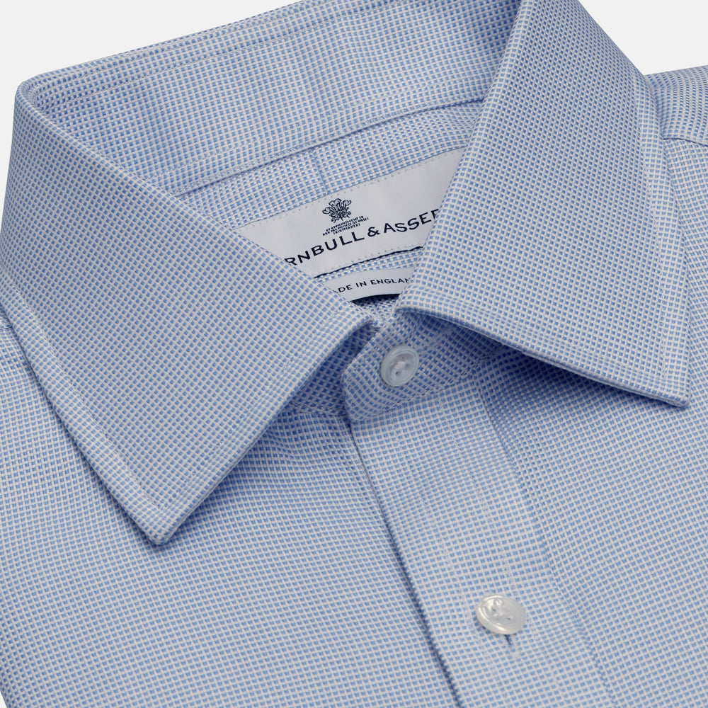 Turnbull & Asser's BLUE MULTI-CHECK COTTON REGULAR FIT SHIRT features a light blue check pattern, pointed collar, and white buttons—an essential classic for any men's wardrobe.