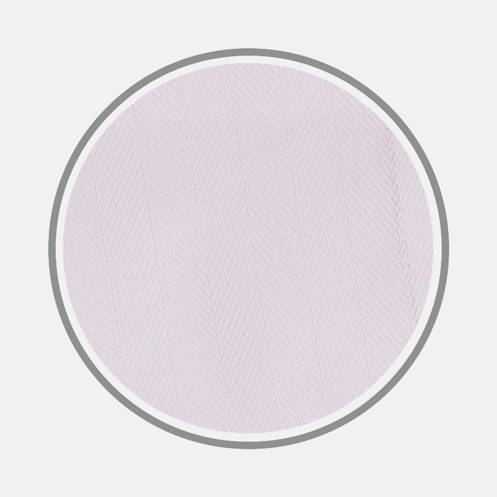 A close-up of Turnbull & Asser’s BESPOKE FABRIC 0010 16 shows pale pink herringbone fabric for custom shirts, displayed in a circular frame on a light gray background.