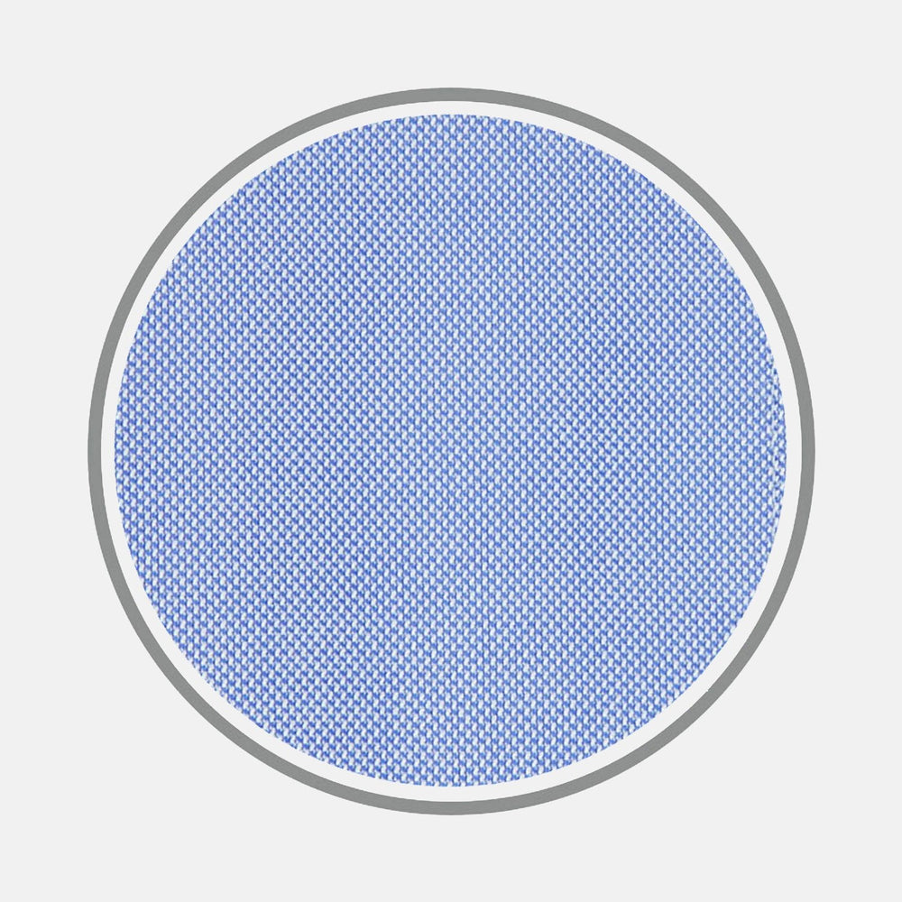 A close-up of Turnbull & Asser’s BESPOKE FABRIC 0015 07 shows a circular blue mesh bordered by gray on white, with a dense weave reflecting the precision of bespoke shirt fabrics and refined monogram styles.