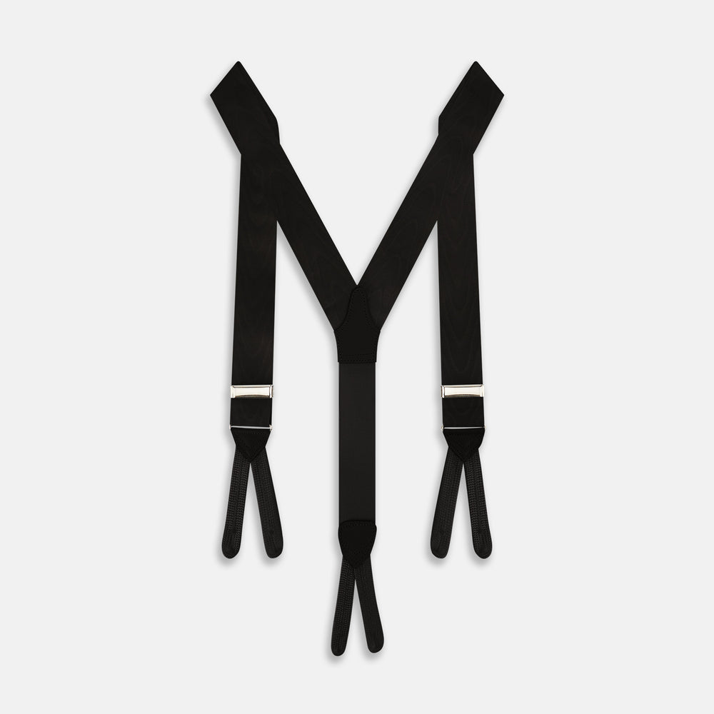 A pair of Turnbull & Asser Casino Royale Black Braces As Seen On Le Chiffre, featuring black moiré fabric, leather loops, and gold-tone adjusters, handmade in England and showcased against a white background.