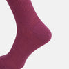View 4 of product A single Turnbull & Asser Mauve Mid-Length Merino Sock is shown upright, foot angled downward, against a plain light gray background. The ribbed sock features a solid mauve color.