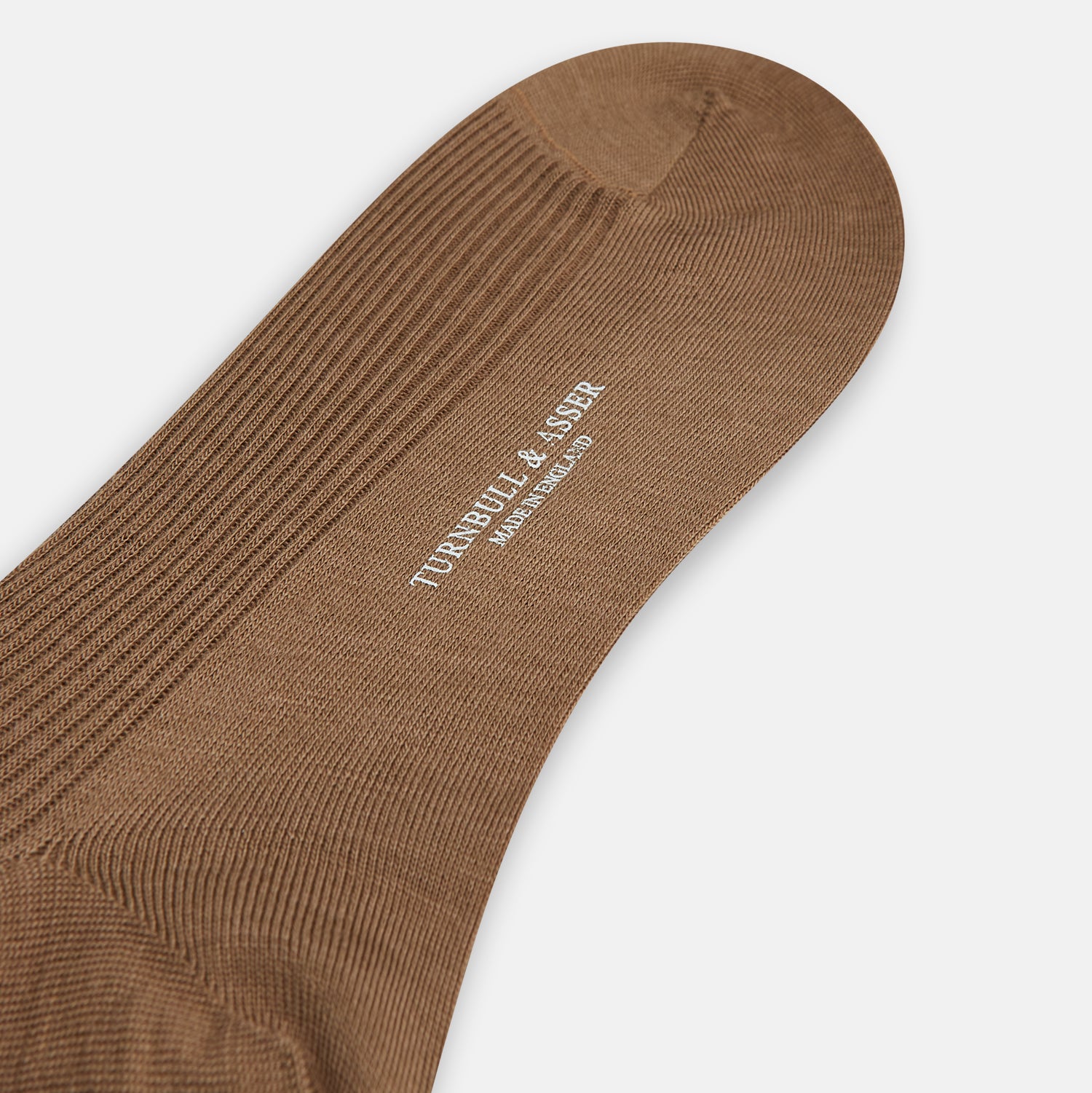 View 3 of product A single Turnbull & Asser Camel Mid-Length Merino Sock stands upright on a plain white background, showcasing its ribbed texture and reinforced toe and heel.