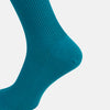 View 4 of product A Turnbull & Asser Turquoise Mid-Length Merino Sock stands upright on a plain light gray background, showcasing its ribbed texture and seamless toe.