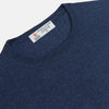 View 2 of product The Blue Crew Neck Merino Wool Jumper by Turnbull & Asser—a classic, long-sleeved staple with ribbed cuffs and hem—lies flat against a white background.