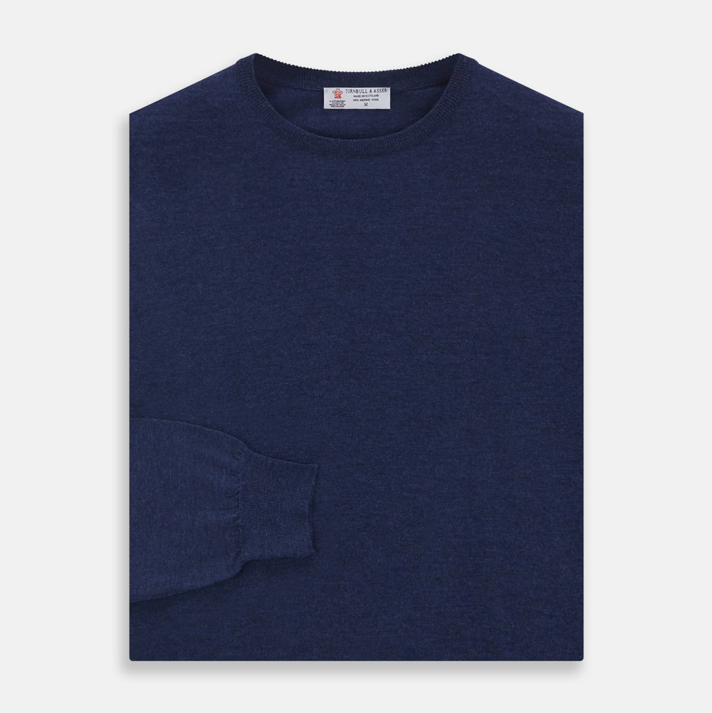 The Blue Crew Neck Merino Wool Jumper by Turnbull & Asser—a classic, long-sleeved staple with ribbed cuffs and hem—lies flat against a white background.