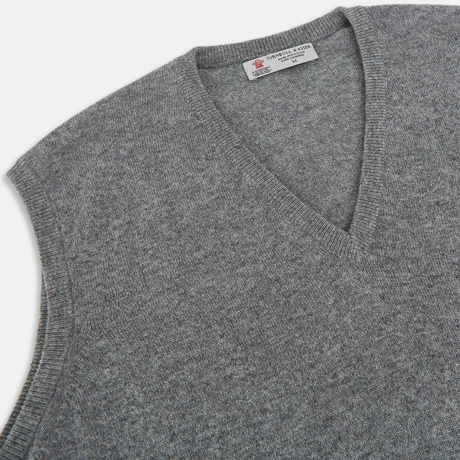 View 2 of product Turnbull & Asser UK’s marl grey sleeveless V-neck vest in cashmere, featuring a ribbed hem and crafted from soft knit fabric, is showcased against a plain white background.