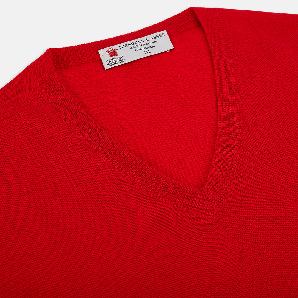 The Turnbull & Asser UK Red long-sleeve V-neck jumper in cashmere features ribbed cuffs and hem, and is shown on a white background.