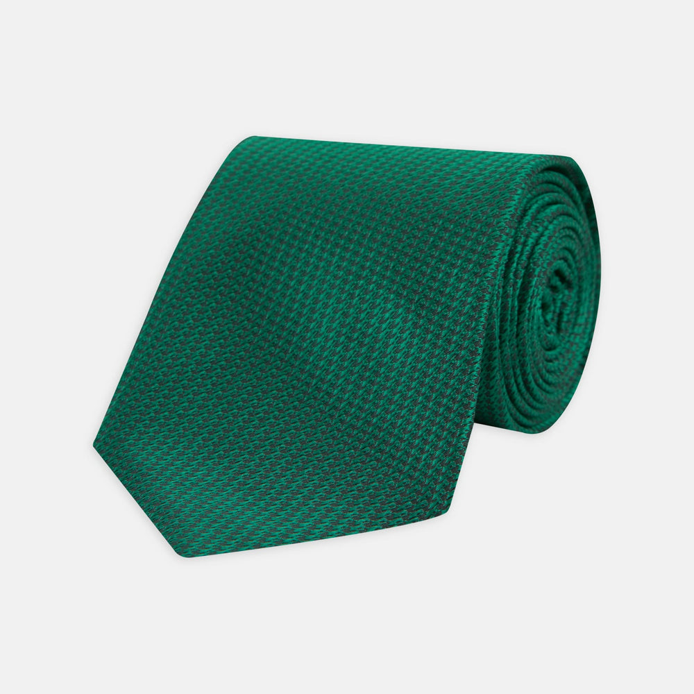 The Turnbull & Asser Green Lace Silk Tie, featuring a textured lace weave, is neatly rolled and displayed on a white background—an elegant, versatile accessory for any wardrobe.