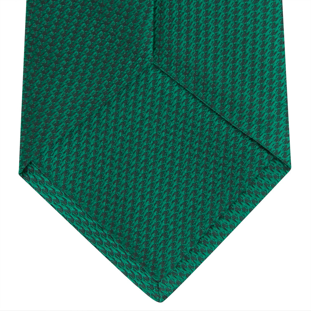 The Turnbull & Asser Green Lace Silk Tie, featuring a textured lace weave, is neatly rolled and displayed on a white background—an elegant, versatile accessory for any wardrobe.