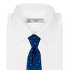 View 2 of product The Turnbull & Asser Royal Blue and White Small Spot Herringbone Silk Tie is displayed rolled at one end on a plain white background, showcasing its classic English silk design with subtle white polka dots.