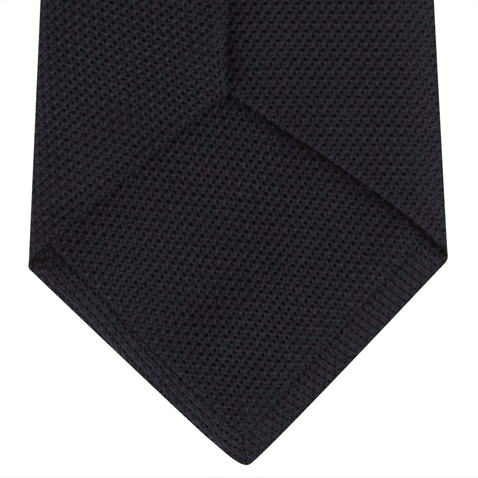 View 4 of product A neatly rolled Turnbull & Asser Navy Grenadine Silk Tie with a textured, knitted appearance is displayed on a white background.