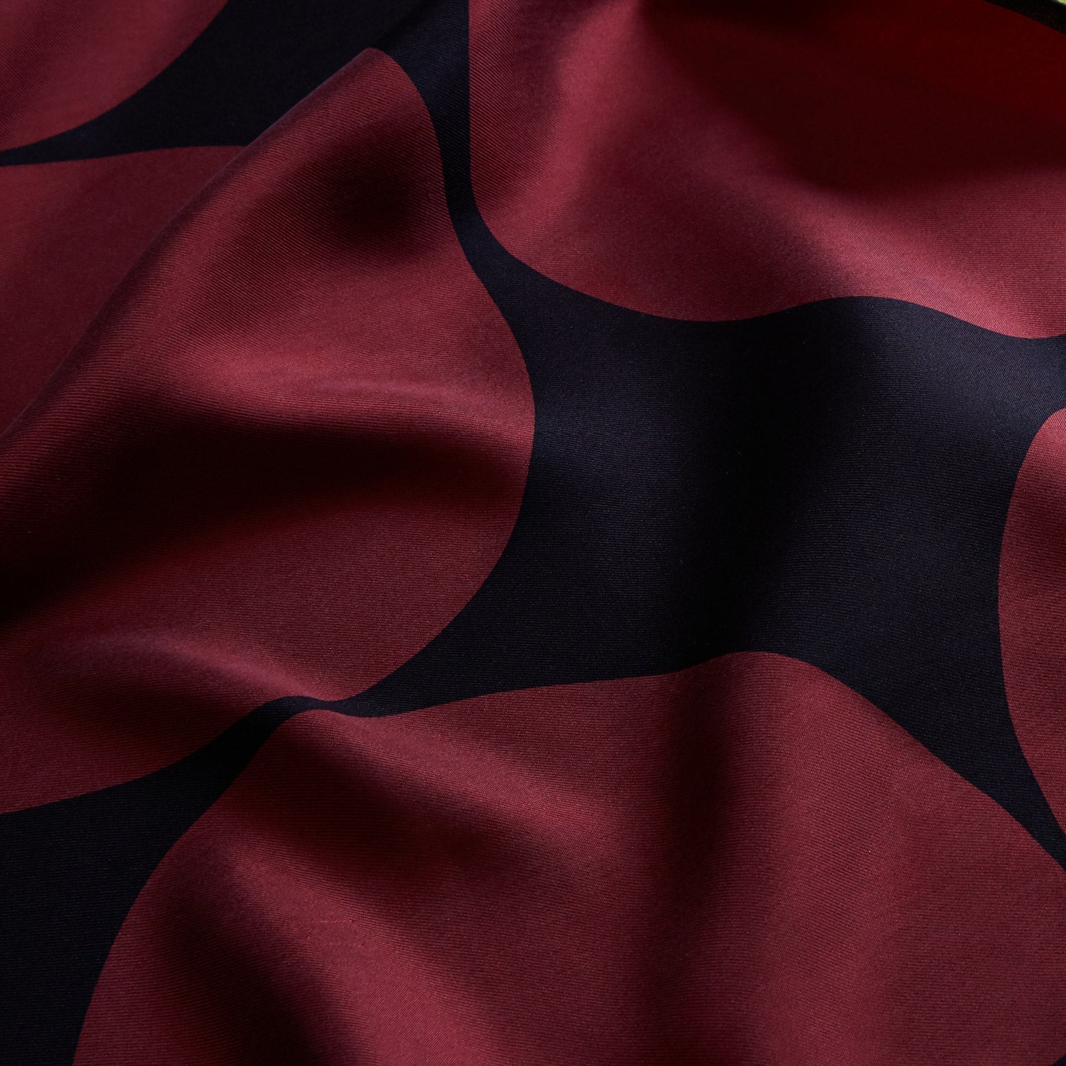 View 2 of product The DR. NO Red and Black Multi Spots Silk Pocket Square by Turnbull & Asser is handmade in England, featuring large red circles on black, with "Turnbull & Asser" and "Made in England" printed in white in the corners.