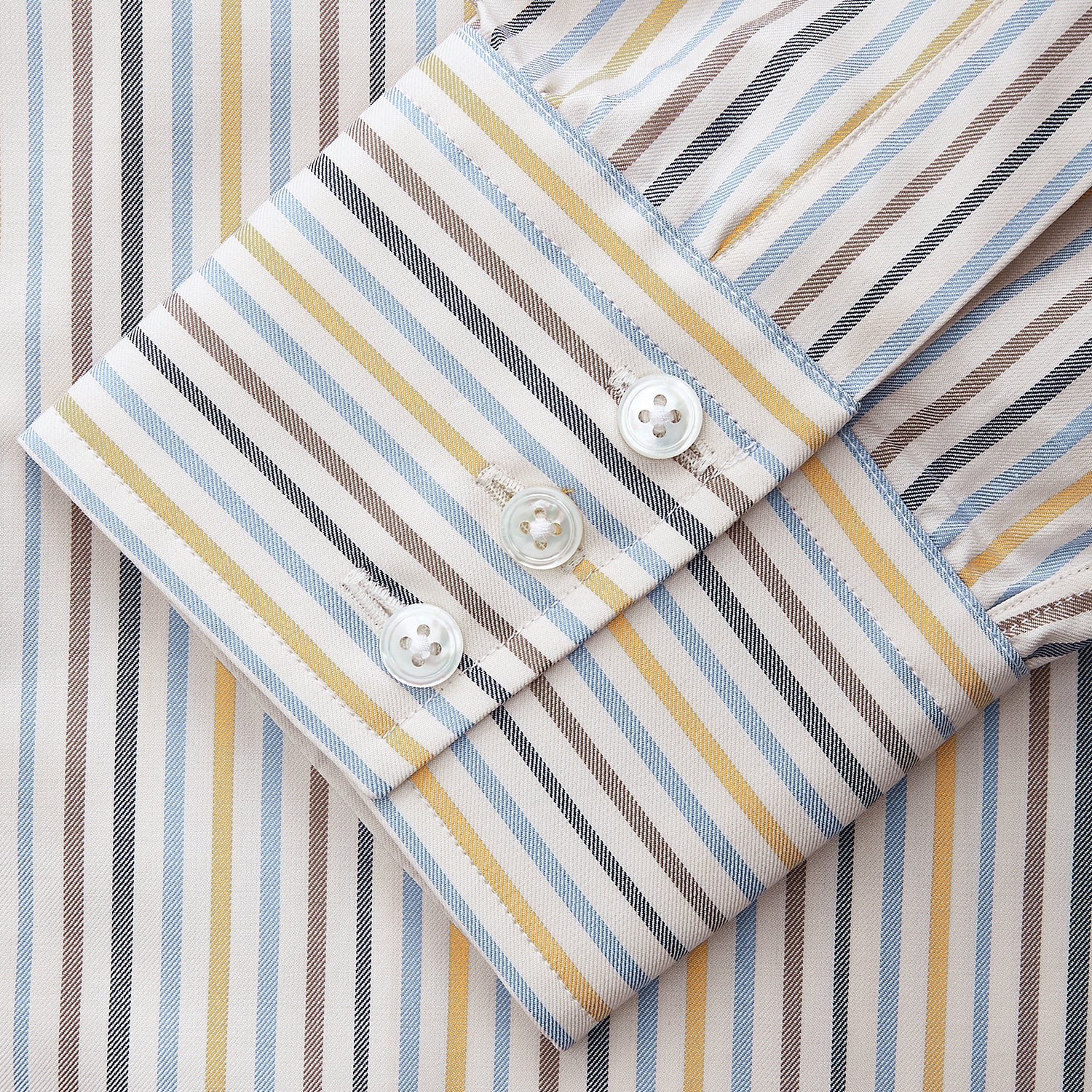 View 3 of product The Turnbull & Asser Yellow Multi Stripe Regular Fit Shirt features a T&A collar, 3 button cuffs, and thin blue, yellow, and light brown stripes on white for a classic formal look.