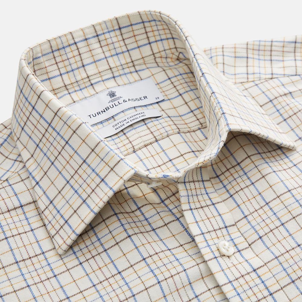 The Turnbull & Asser Brown Multi Check Regular Fit Cotton-Cashmere Shirt features a white base with blue, yellow, and brown checks, T&A collar, and 3 button cuffs for a smart-casual look.