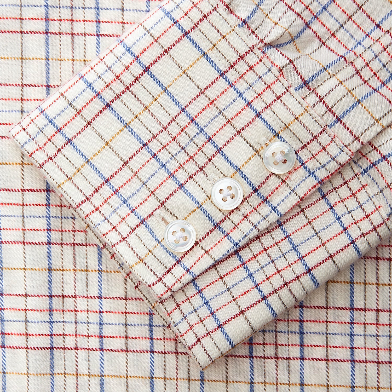 View 3 of product The Turnbull & Asser Red Multi Check Regular Fit Cotton-Cashmere Shirt features a T&A collar, 3 button cuffs, and a multicolored check pattern on white, shown laid flat against a white surface.