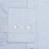 View 3 of product The Turnbull & Asser Blue Cashmerello Mayfair Shirt is a light blue cotton-cashmere blend with long sleeves, pointed collar, white buttons, and buttoned cuffs, shown on a plain white background.