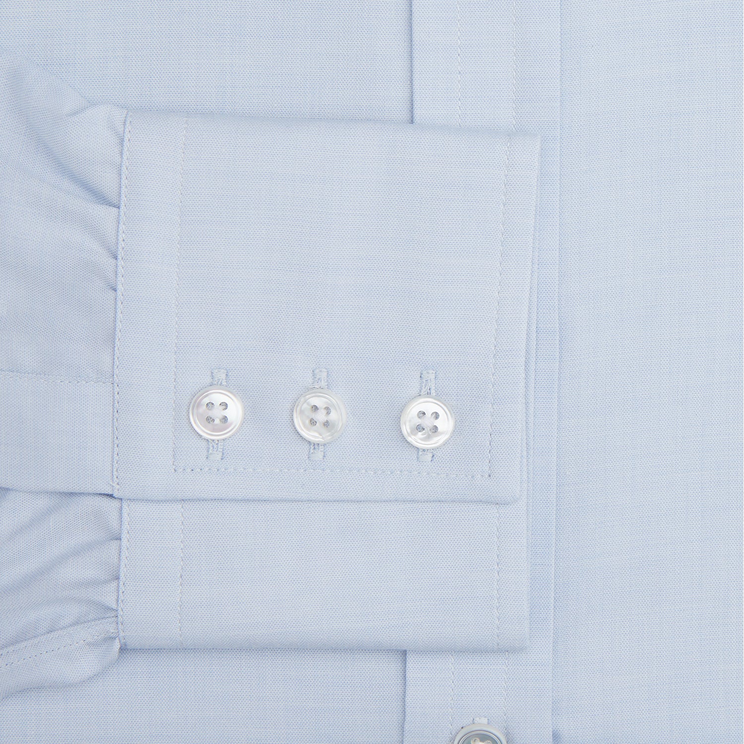 View 3 of product The Turnbull & Asser Blue Cashmerello Mayfair Shirt is a light blue cotton-cashmere blend with long sleeves, pointed collar, white buttons, and buttoned cuffs, shown on a plain white background.