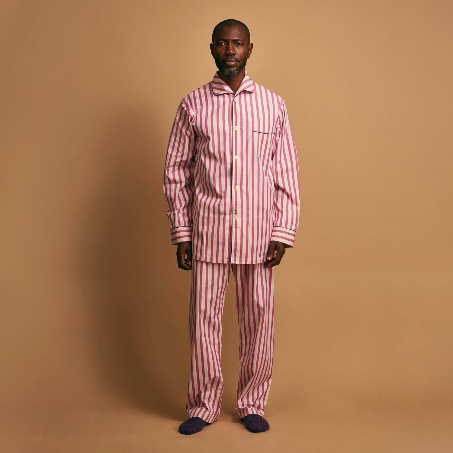 View 2 of product The Turnbull & Asser Pink Candy Stripe Cotton Traditional Pyjamas feature long sleeves, pants, vertical pink candy stripes, a camp collar shirt with buttons, chest pocket, and navy trim on the pocket and cuffs.
