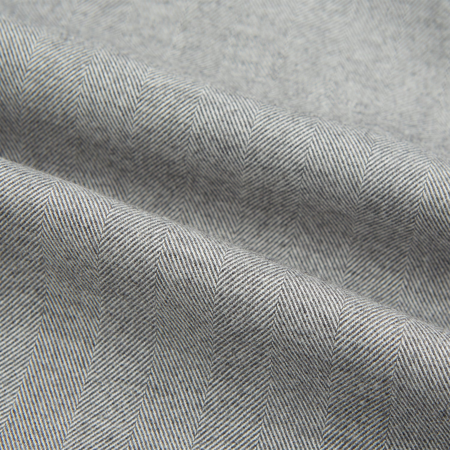 View 6 of product The Turnbull & Asser Grey Herringbone Chelsea Shirt features long sleeves, a chest pocket, classic collar, and buttoned cuffs, adding refined style to smart-casual outfits—shown here against a plain white background.