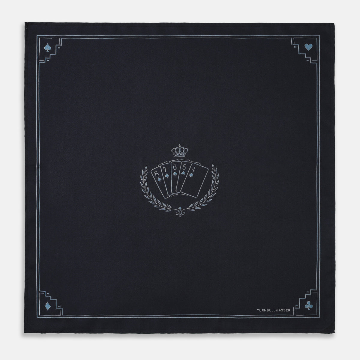 View 1 of product Introducing the Casino Royale Midnight Blue Crest Pocket Square in Silk from Turnbull & Asser UK—a midnight blue silk pocket square bordered in white, featuring playing card suit symbols at each corner and a central motif depicting the 10, J, Q, and K of spades beneath a crown and laurel. Perfect as a sophisticated Casino Royale or Bond tuxedo accessory, with “Turnbull & Asser” elegantly displayed in the lower right.