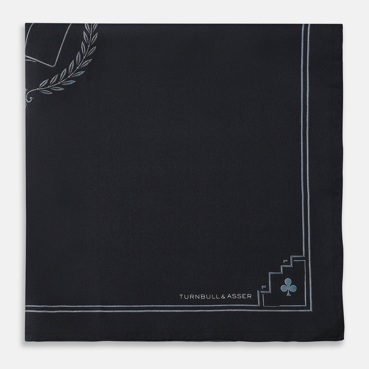 View 3 of product Introducing the Casino Royale Midnight Blue Crest Pocket Square in Silk from Turnbull & Asser UK—a midnight blue silk pocket square bordered in white, featuring playing card suit symbols at each corner and a central motif depicting the 10, J, Q, and K of spades beneath a crown and laurel. Perfect as a sophisticated Casino Royale or Bond tuxedo accessory, with “Turnbull & Asser” elegantly displayed in the lower right.