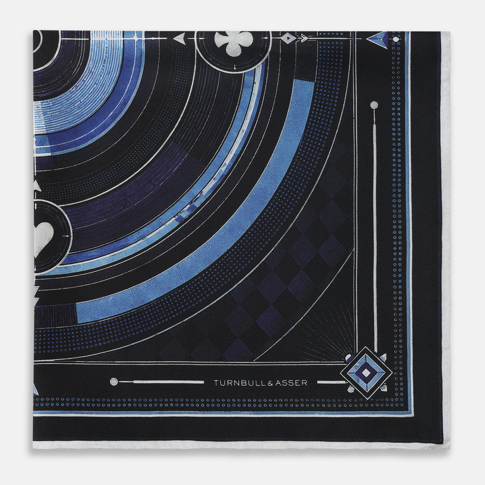 Presenting the Casino Royale Midnight Blue Target Pocket Square in Silk from Turnbull & Asser UK—a luxurious silk square scarf adorned with concentric circles in rich midnight blue and black, accented by playing card suit symbols (spade, diamond, club, heart) at each cardinal point and striking geometric patterns in the corners. This elegant accessory is perfect for adding a touch of sophisticated intrigue to your ensemble.