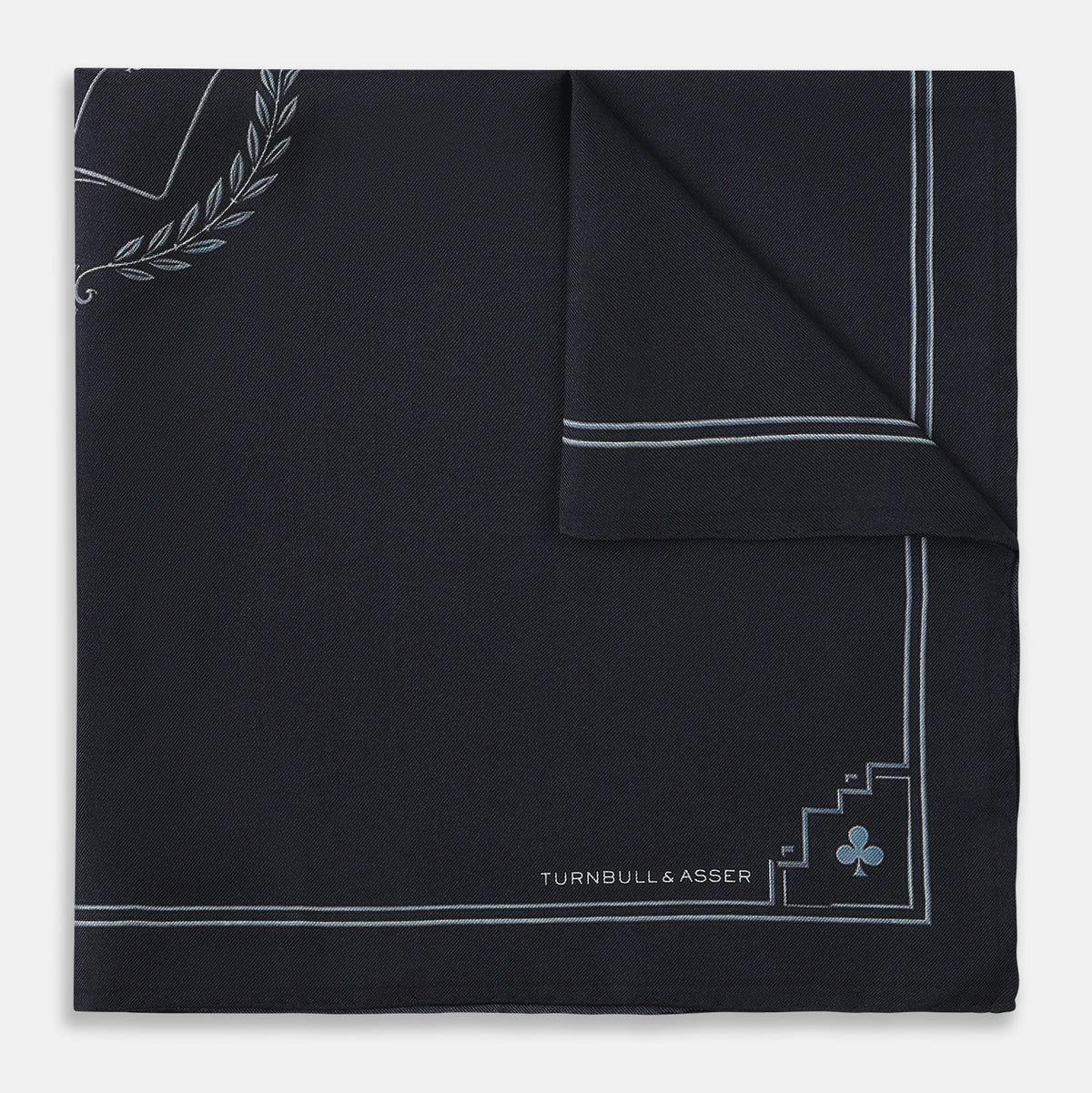 View 4 of product Introducing the Casino Royale Midnight Blue Crest Pocket Square in Silk from Turnbull & Asser UK—a midnight blue silk pocket square bordered in white, featuring playing card suit symbols at each corner and a central motif depicting the 10, J, Q, and K of spades beneath a crown and laurel. Perfect as a sophisticated Casino Royale or Bond tuxedo accessory, with “Turnbull & Asser” elegantly displayed in the lower right.