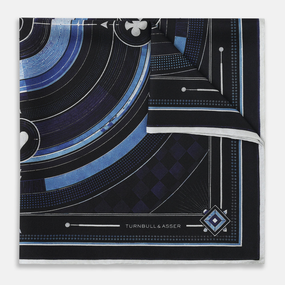 Presenting the Casino Royale Midnight Blue Target Pocket Square in Silk from Turnbull & Asser UK—a luxurious silk square scarf adorned with concentric circles in rich midnight blue and black, accented by playing card suit symbols (spade, diamond, club, heart) at each cardinal point and striking geometric patterns in the corners. This elegant accessory is perfect for adding a touch of sophisticated intrigue to your ensemble.