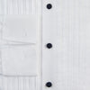 View 6 of product The Casino Royale White Dress Shirt in Cotton by Turnbull & Asser UK is a long-sleeve white dress shirt, crafted from crisp white cotton poplin with a pleated bib front, black buttons, and a classic collar, shown laid flat on a white background.