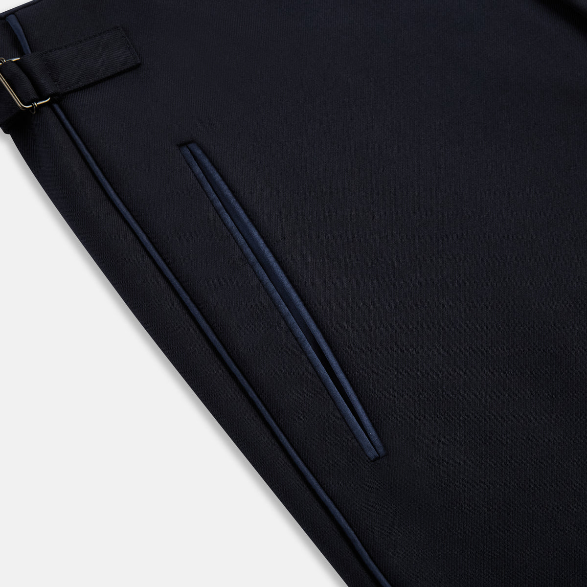 View 5 of product The Casino Royale Midnight Blue Tuxedo Trousers in Wool by Turnbull & Asser UK are shown from the back, expertly crafted from virgin wool in a signature tuxedo style, featuring two buttoned back pockets and adjustable side tabs at the waistband.