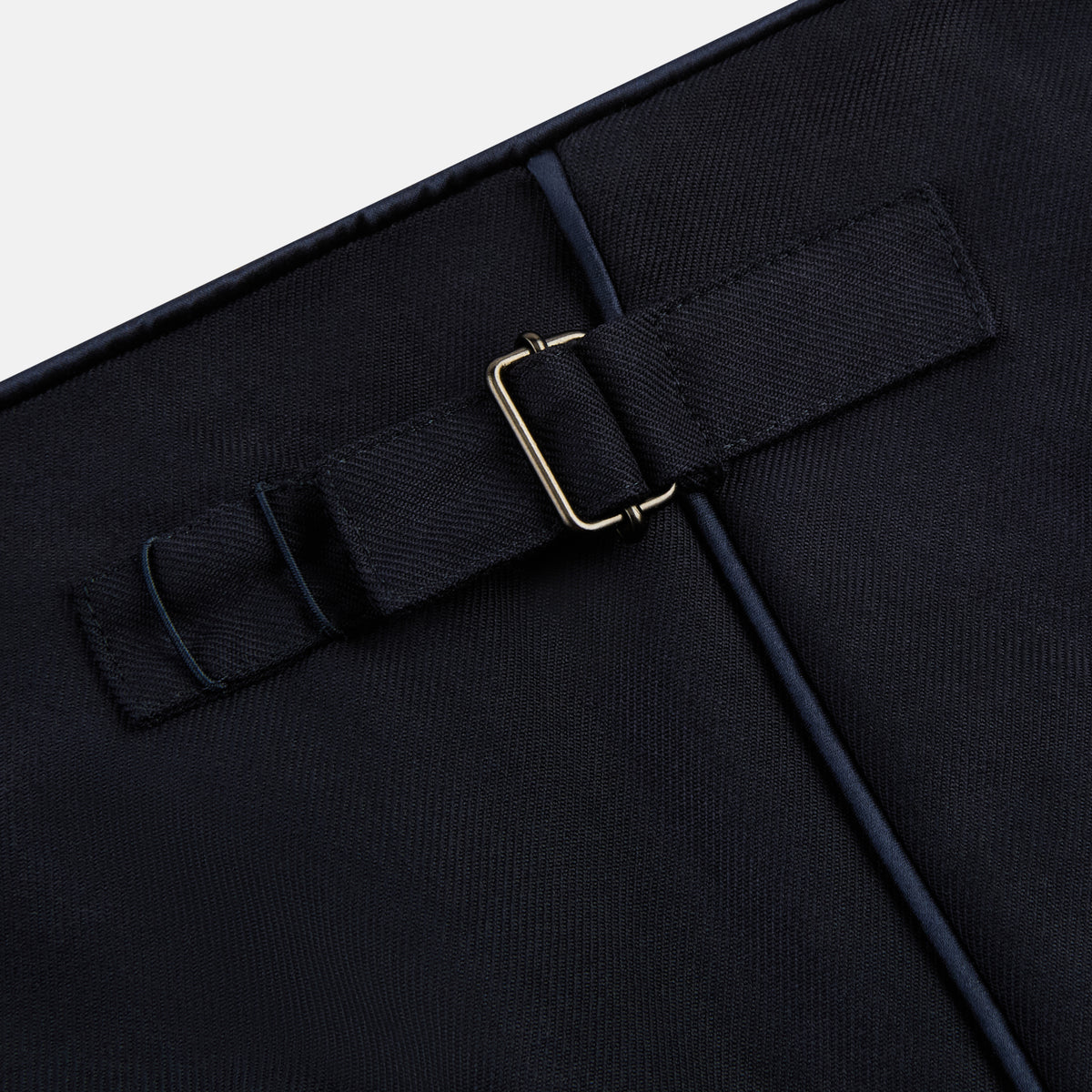 View 9 of product The Casino Royale Midnight Blue Tuxedo Trousers in Wool by Turnbull & Asser UK are shown from the back, expertly crafted from virgin wool in a signature tuxedo style, featuring two buttoned back pockets and adjustable side tabs at the waistband.