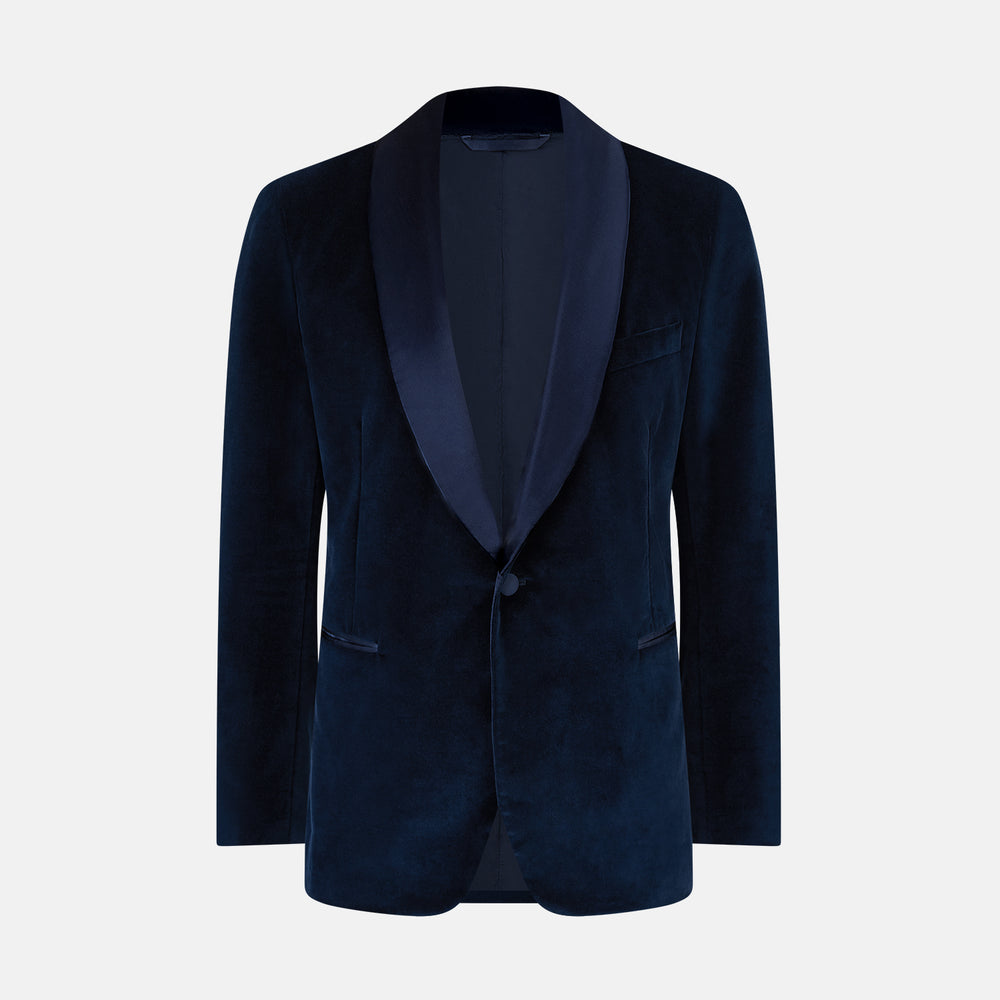 Turnbull & Asser UK’s Casino Royale Midnight Blue Tuxedo Jacket in Cotton Velvet, featuring a single button closure and a luxurious silk-satin shawl lapel, is showcased against a plain white background.