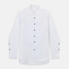View 10 of product The Casino Royale White Dress Shirt in Cotton by Turnbull & Asser UK is a long-sleeve white dress shirt, crafted from crisp white cotton poplin with a pleated bib front, black buttons, and a classic collar, shown laid flat on a white background.